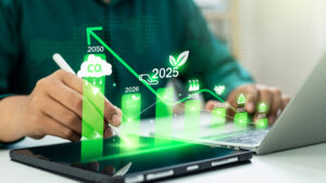 A man sits at his computer evaluating a renewable energy chart outlining energy savigs for businesses.