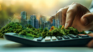 An energy risk management consultant adds up savings on a calculator. A cityscape and greenery is in the background.