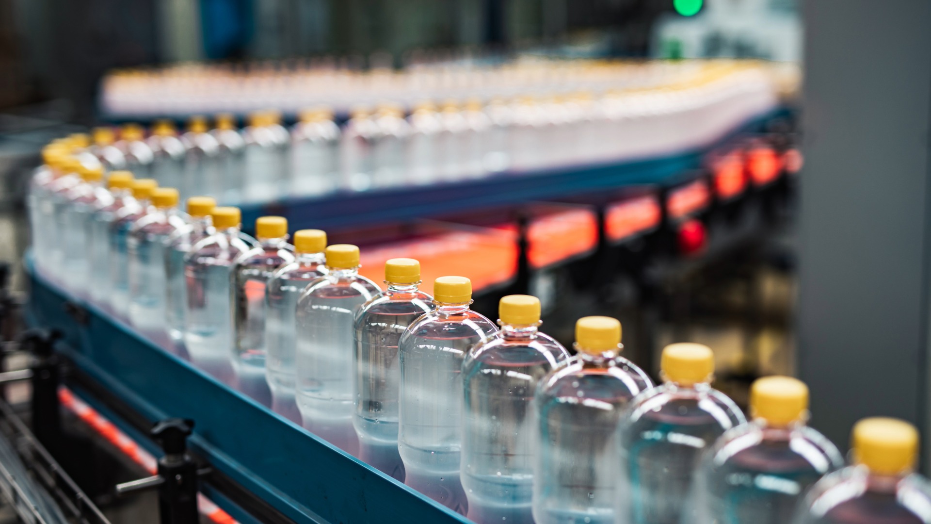 Bottles are filled and sealed in a manufacturing facility.