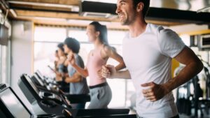 People working out on a treadmill at the gym.
