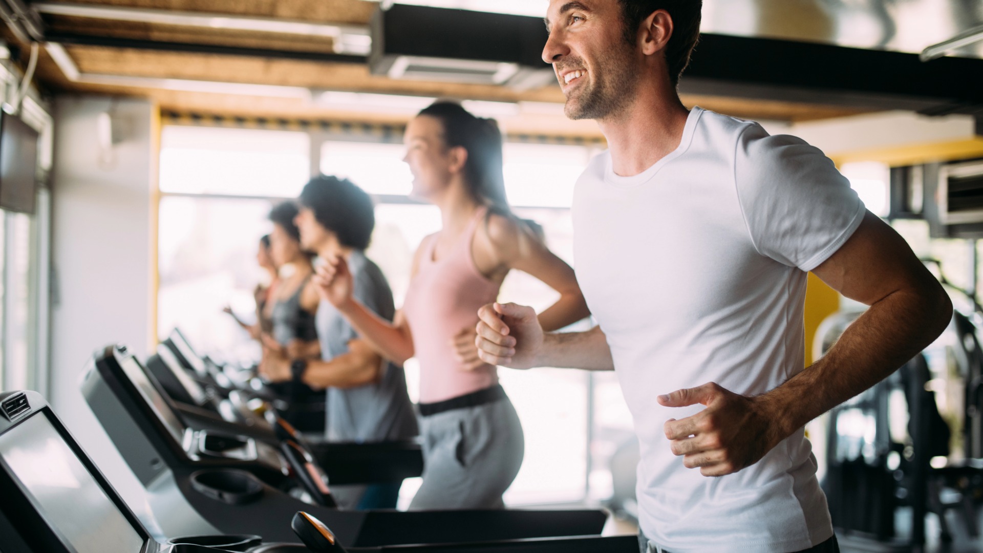People working out on a treadmill at the gym.