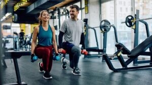 A man and a woman work out in a fitness center.