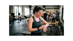 A woman works out in a busy gym.