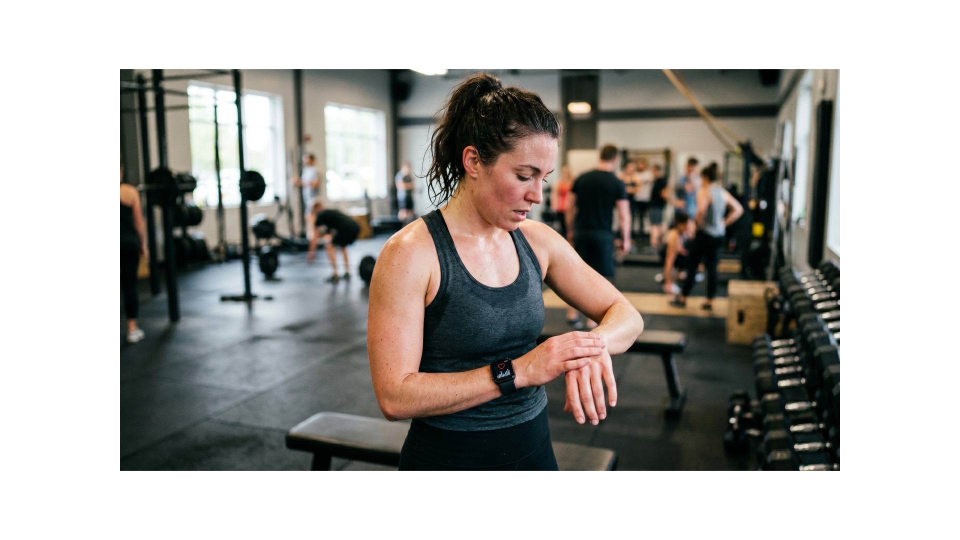 A woman works out in a busy gym.